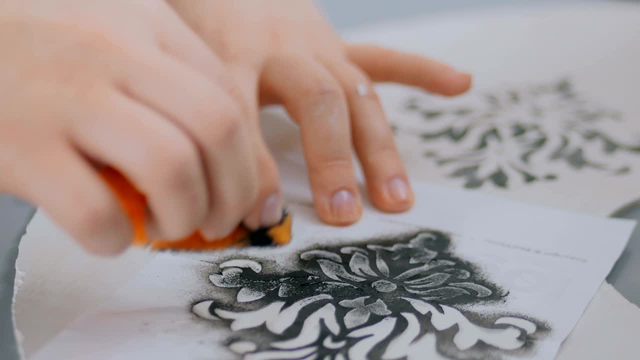 manos de mujer pintando círculo de madera