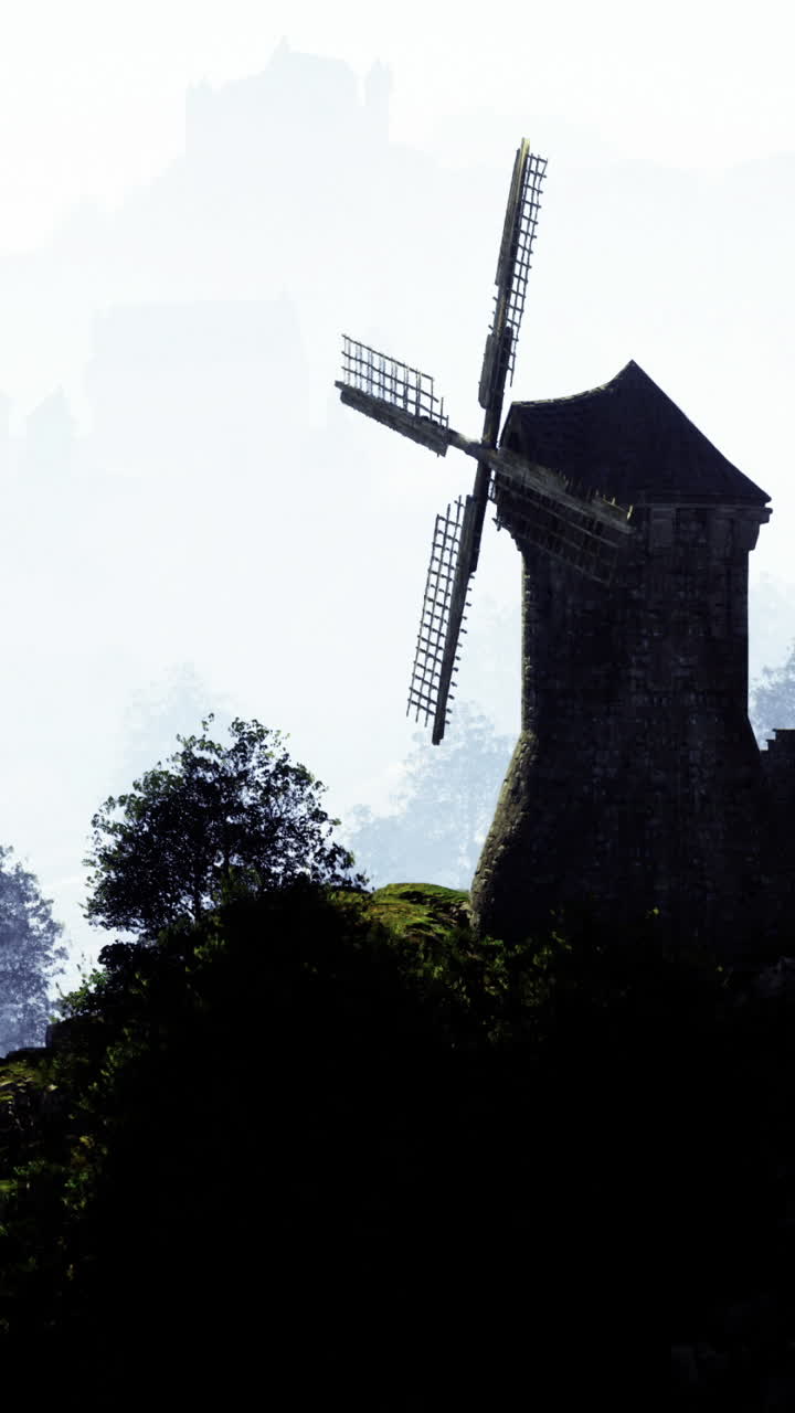 Majestic windmill stands tall in misty landscape during early morning