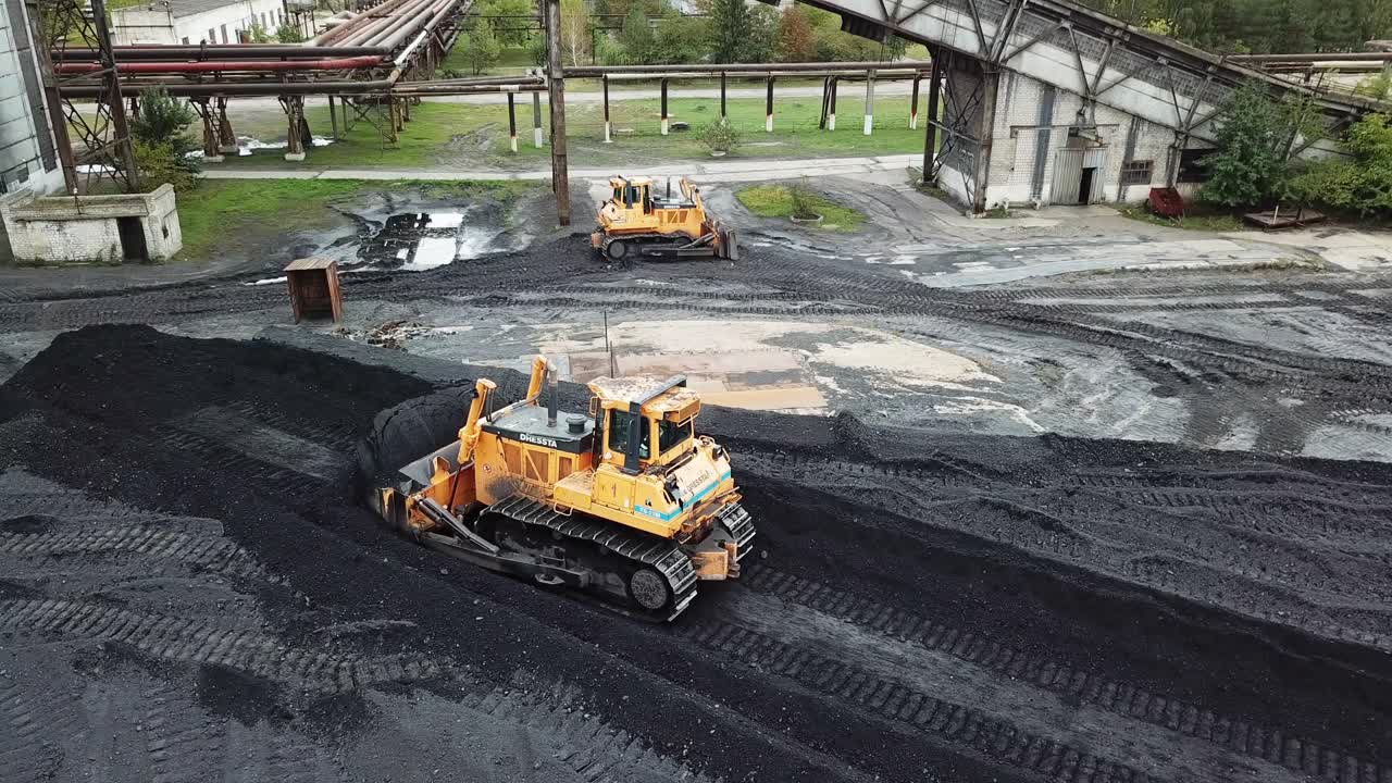 Coal handling operations at the factory. Crawler bulldozer works. Aerial view.