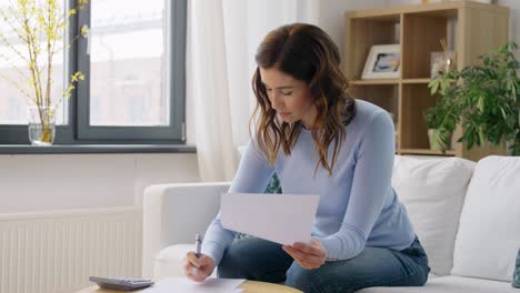 Grauhaarige-ältere-Frau,-Die-Mit-Papieren-Arbeitet-Und-Zahlungen-Berechnet.-Ältere-Frau-Mit-Grauem-Haar,-Die-An-Papierkram-Arbeitet-Und-Rechnungen-Berechnet