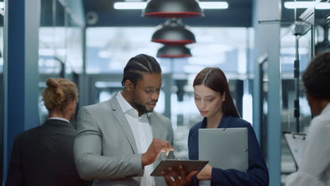 multiracial couple speaking in office. businessman showing meeting topic to girl