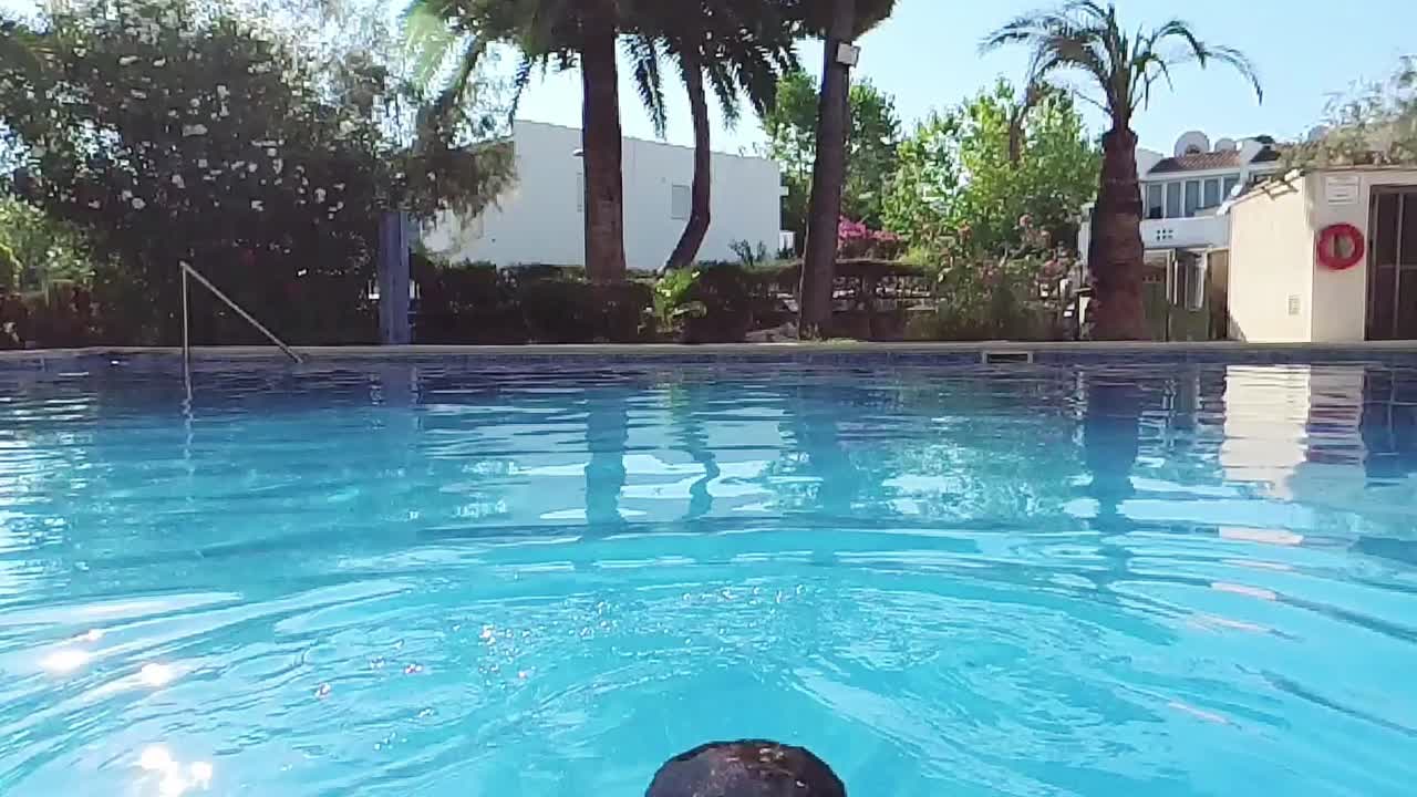 Mand, der kommer op af vandet i swimmingpoolen