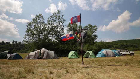 Evento-De-Exploración-Internacional-En-Eslovaquia,-Carpas-Y-Bandera-En-El-Campamento,-Dolly