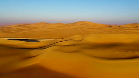 aerial view of a man walking on dunes during the sunset, u.a.e.