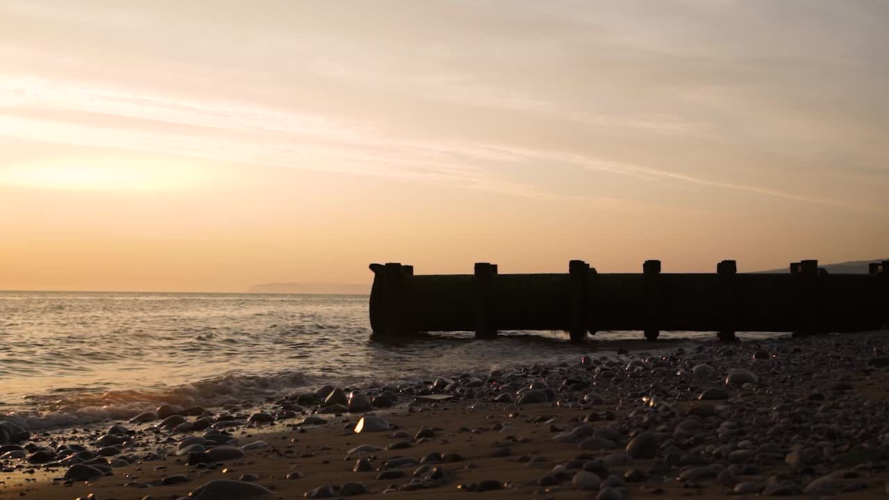 Industriellt avloppsrör på en stenig strand vid havet, miljö.