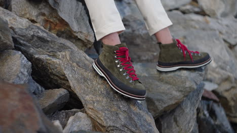 closeup of a man's hiking shoes resting on a rocky mountain in the italian alps