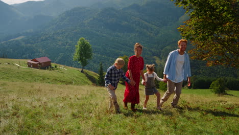 Familia-Despreocupada-Camina-Junta-En-Una-Pendiente-Verde.-Padres-Disfrutando-De-La-Naturaleza-Con-Niños.