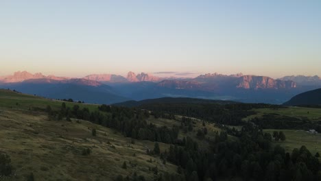 Toma-Aérea-De-Drones-De-Los-Alpes-Mientras-Se-Pone-El-Sol-Con-Cabañas-Y-Tierras-De-Cultivo,-Hermosa-Naturaleza