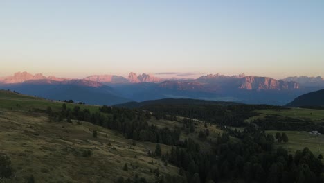 aerial drone shot of the alps while sunset with huts and farmland, beautiful nature