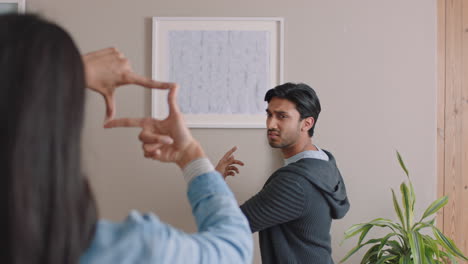 una joven pareja se muda a una nueva casa. los propietarios cuelgan fotos decorando la casa juntos disfrutando de una mudanza exitosa en el apartamento.