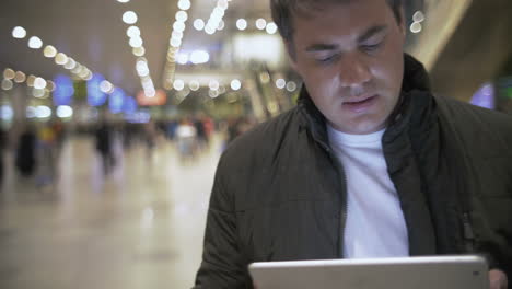 Junger-Mann-Arbeitet-Mit-Touchpad-Am-Flughafen