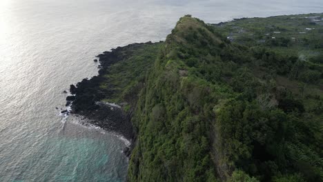 epic drone shot of lush green cliff meeting the ocean in comoros