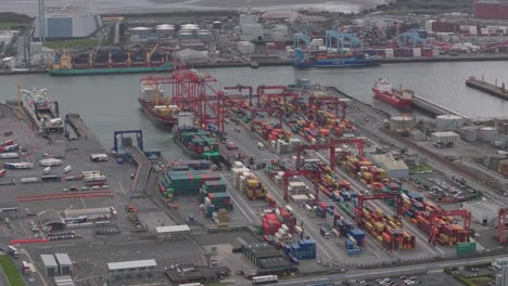 busy container terminal with cranes and cargo ships at dublin port, ireland