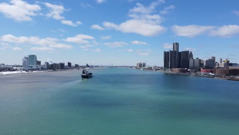 freighter ship sailing in middle of detroit river between michigan and windsor, aerial view