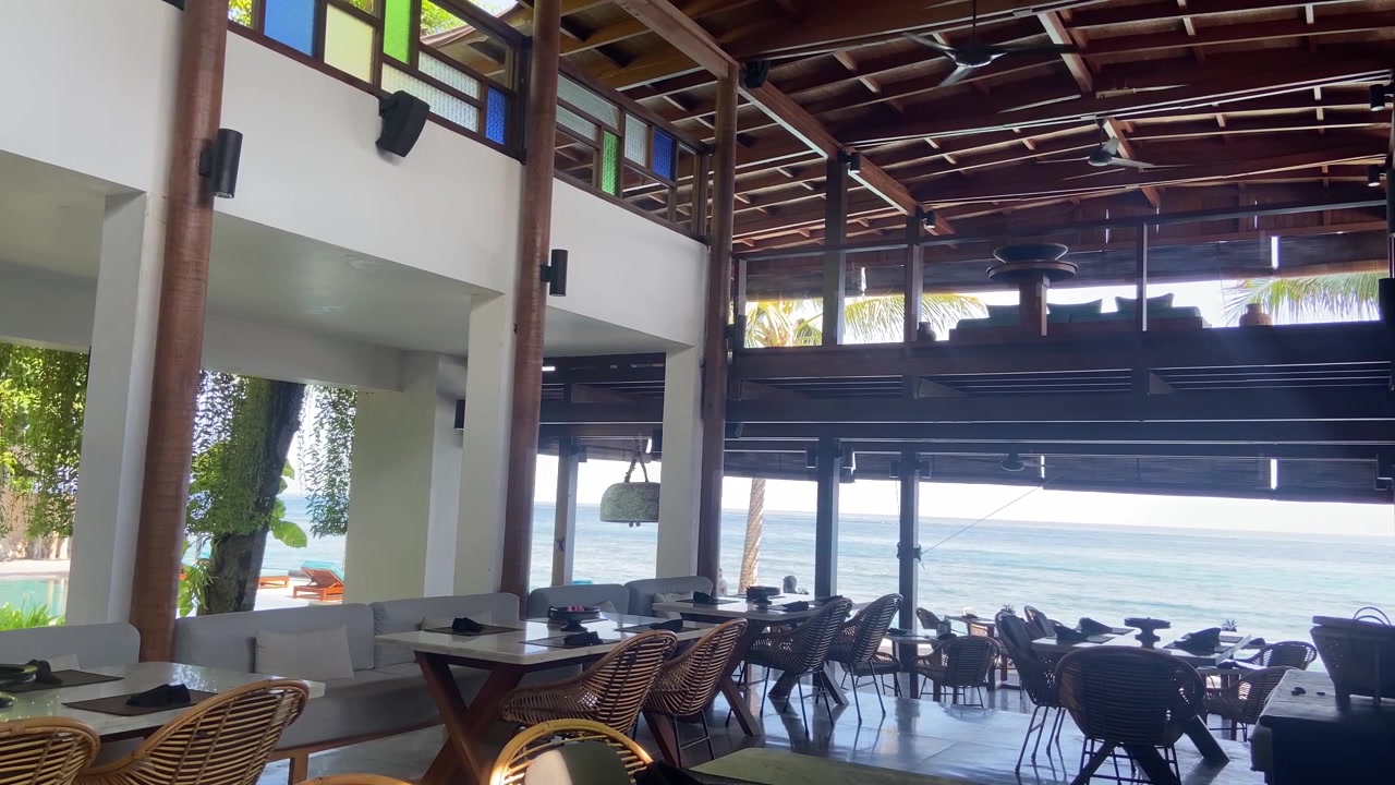 Restaurante tropical vacío frente a la playa con vista al mar