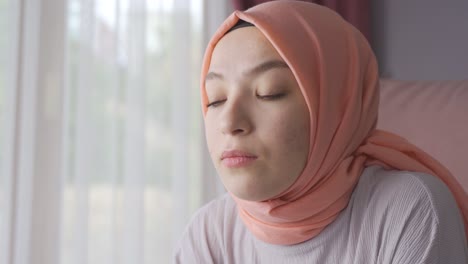 muslim woman at home unhappy and thoughtful.