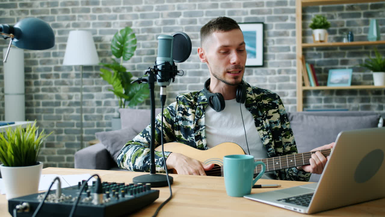 Uomo che canta e suona la chitarra nello studio casalingo
