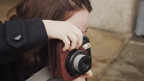 카메라와 함께 외부 사진을 찍는 젊은 백인 갈색 머리 여자 슬로우 모션을 닫습니다