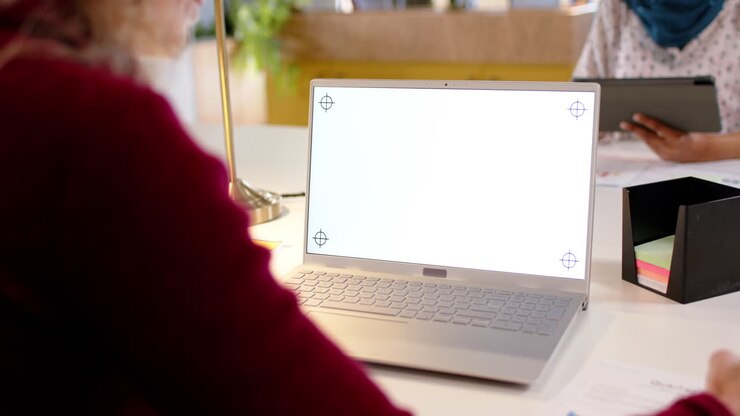Donna d'affari caucasica in abbigliamento casual che utilizza un laptop con spazio per la copia sullo schermo, in ufficio, al rallentatore