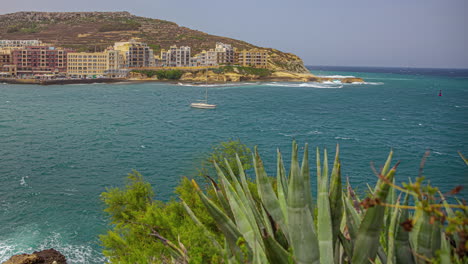 high angle shot of town buildings beside the blue sea on a sunny day on a bright sunny day in timelapse