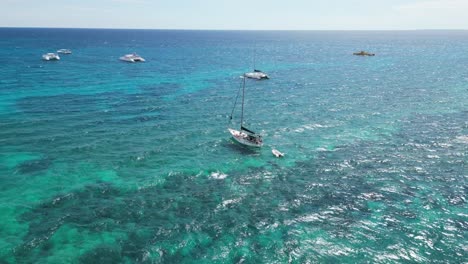 Aerial-shot-of-a-sailboat-near-the-beach-at-Bahayibe,-Dominican-Republic
