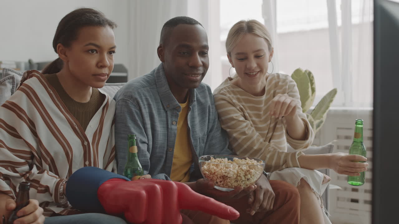 Homem e mulher assistindo esportes na TV