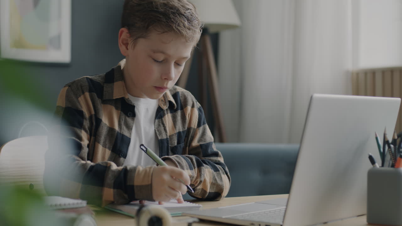 niño haciendo la tarea en una computadora portátil