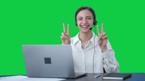 chica feliz del centro de llamadas india mostrando el signo de victoria pantalla verde