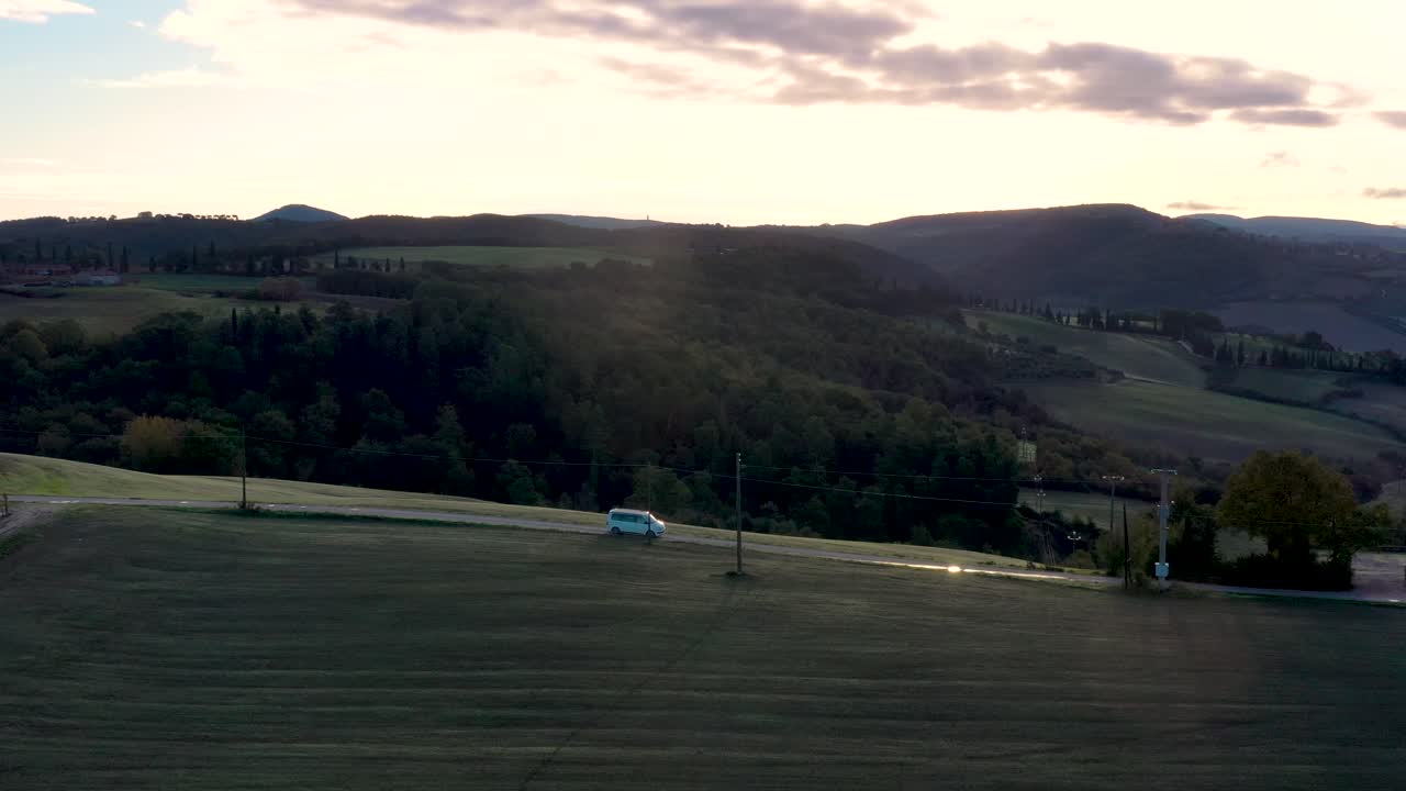 4K Drone aerial footage of a car , vanmoving on empty  road in autumn fields in Tuscany, Italy. Environment, traveling, car sharing concept