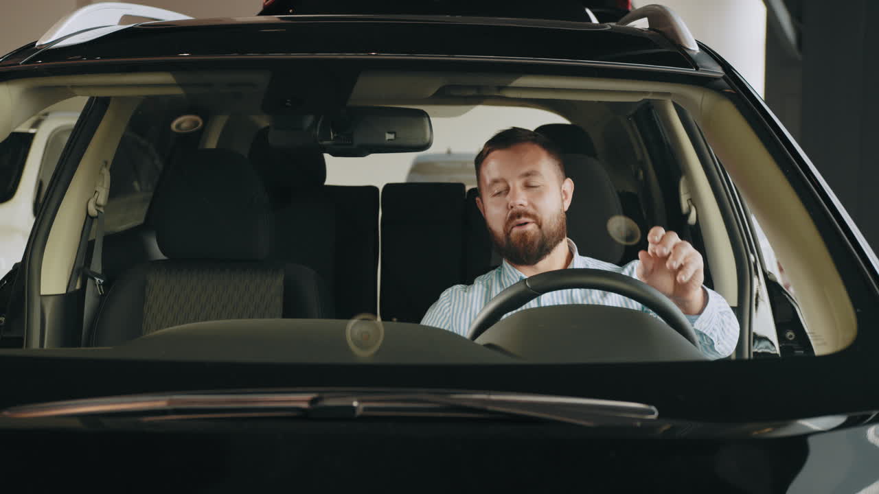 hombre mirando un coche nuevo en una sala de exposiciones