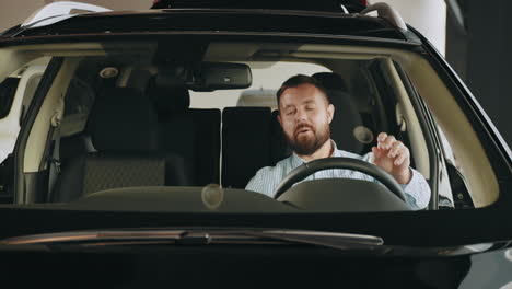 man looking at a new car in a showroom
