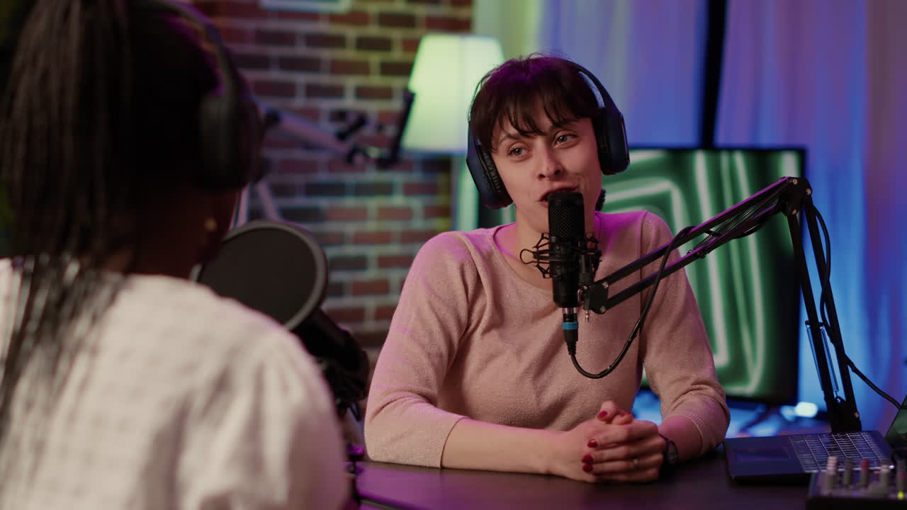 Selective focus on online radio host doing high five hand gesture with african american singer during live podcast