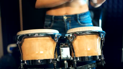 close up of hands playing djembe drum