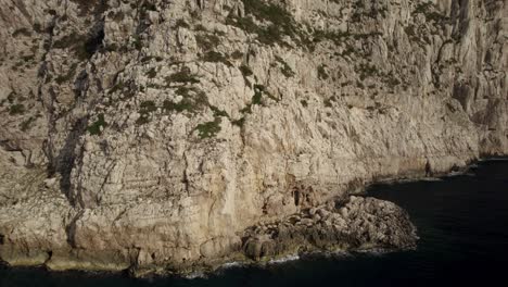 órbita-Cercana-Aérea-Sobre-Los-Acantilados-De-Capo-Coccia,-Cerdeña,-Italia