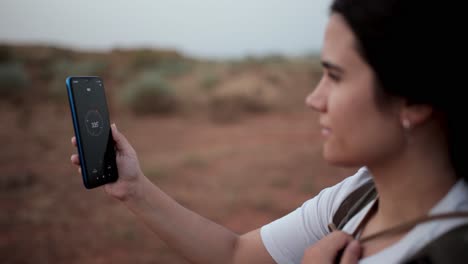 Unrecognizable-woman-using-compass-in-desert