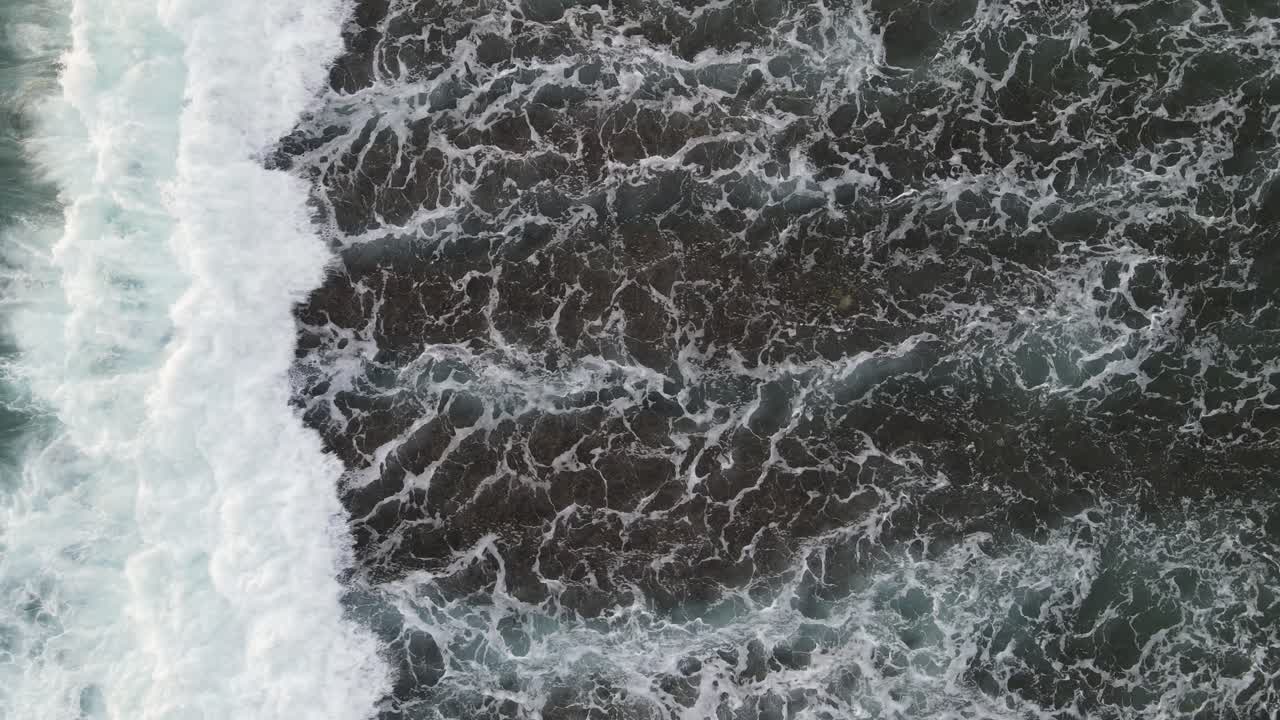 Aerial Top-Down View of Ocean Waves Crashing and Foaming
