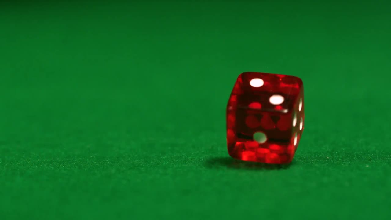 los dados rojos rodando en la mesa del casino