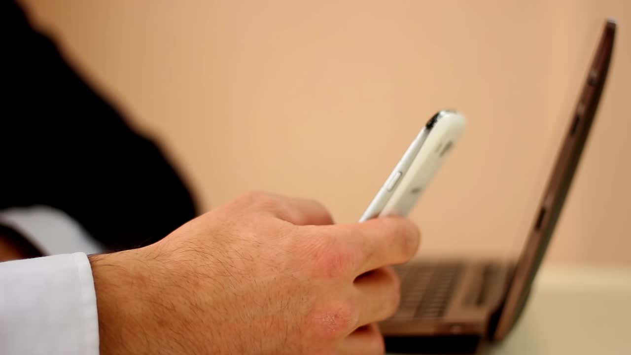 hombre de negocios usando un teléfono inteligente y una computadora portátil en la oficina disparar de cerca