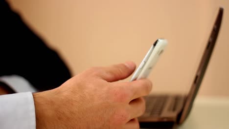 hombre de negocios usando un teléfono inteligente y una computadora portátil en la oficina disparar de cerca