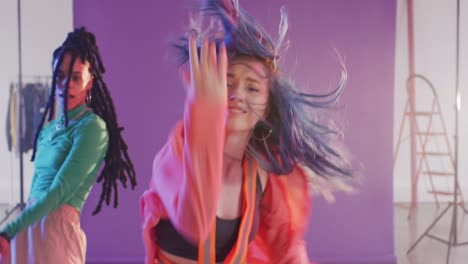 portrait of happy diverse female dancers dancing in dance studio, slow motion