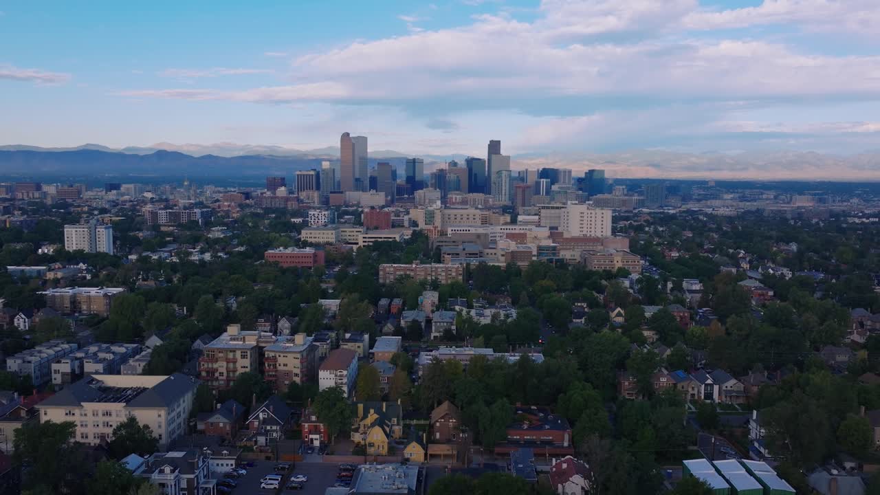 Skyline del centro di Denver sotto un cielo blu e l'orizzonte montuoso, carrellata aerea simmetrica orizzontale con drone di media distanza