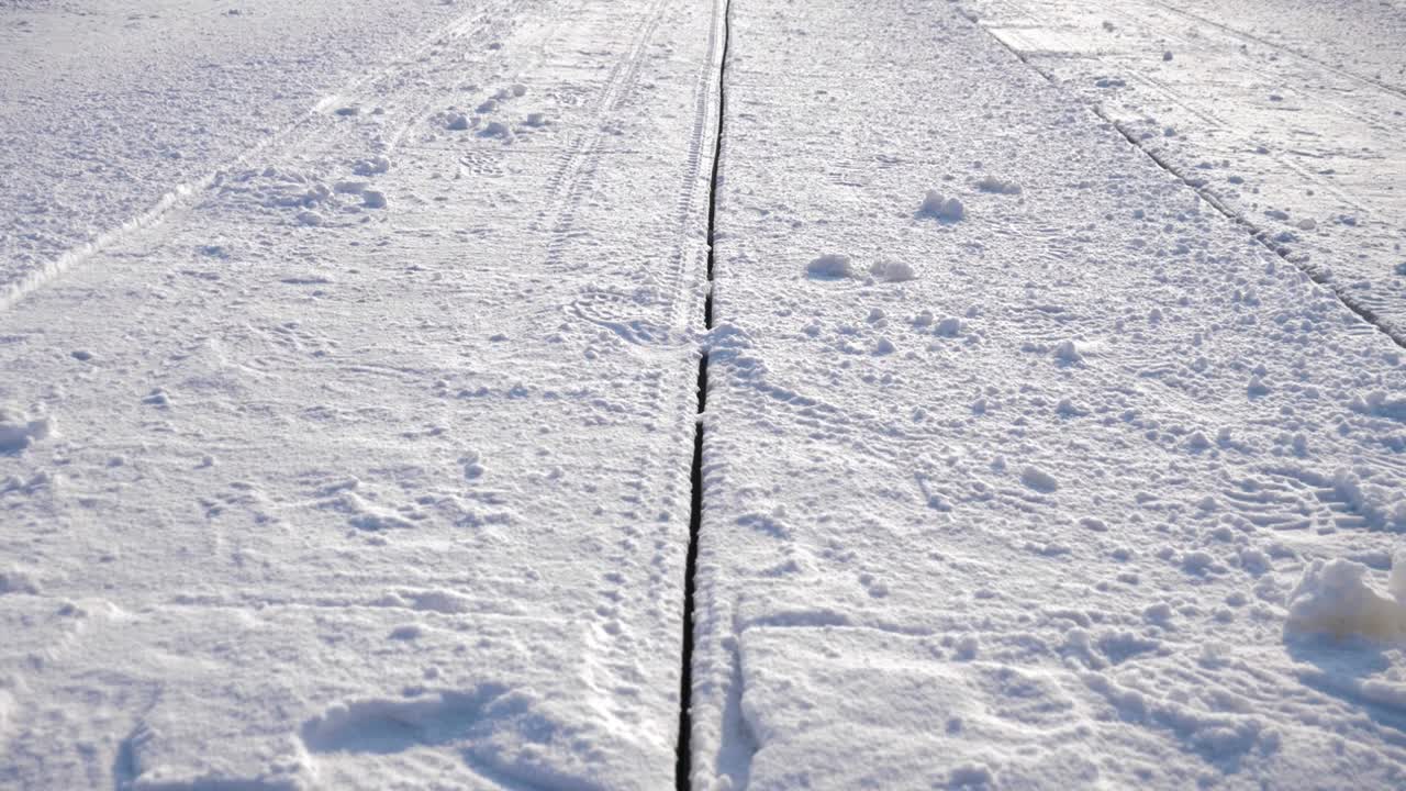 Handheld slow-motion shot of a precise cut line in thick ice that was created by an industrial cutting machine on the frozen Songhua River in Harbin. Ice Block Harvesting in China