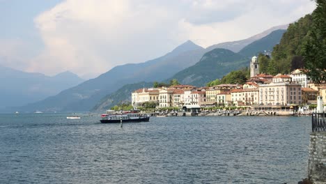 ferry boat arrives at beautiful tourist town of bellagio, lake como, italy