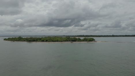 toma aérea de drones volando alrededor de una pequeña isla tropical desierta