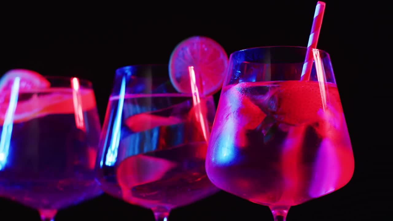 Primer plano de bebidas con fruta sobre fondo negro.