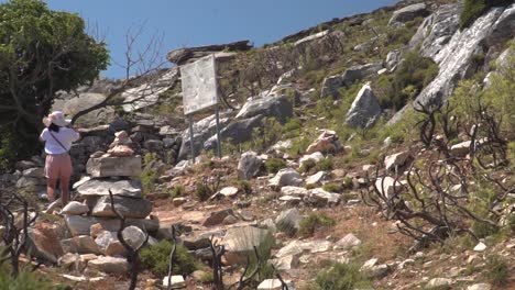 Vista-Panorámica-Derecha-A-Través-De-Una-Niña-Caminando-Por-Un-Paisaje-árido-Y-Seco-Con-Piedras,-árboles-Muertos-Y-Algo-De-Vegetación