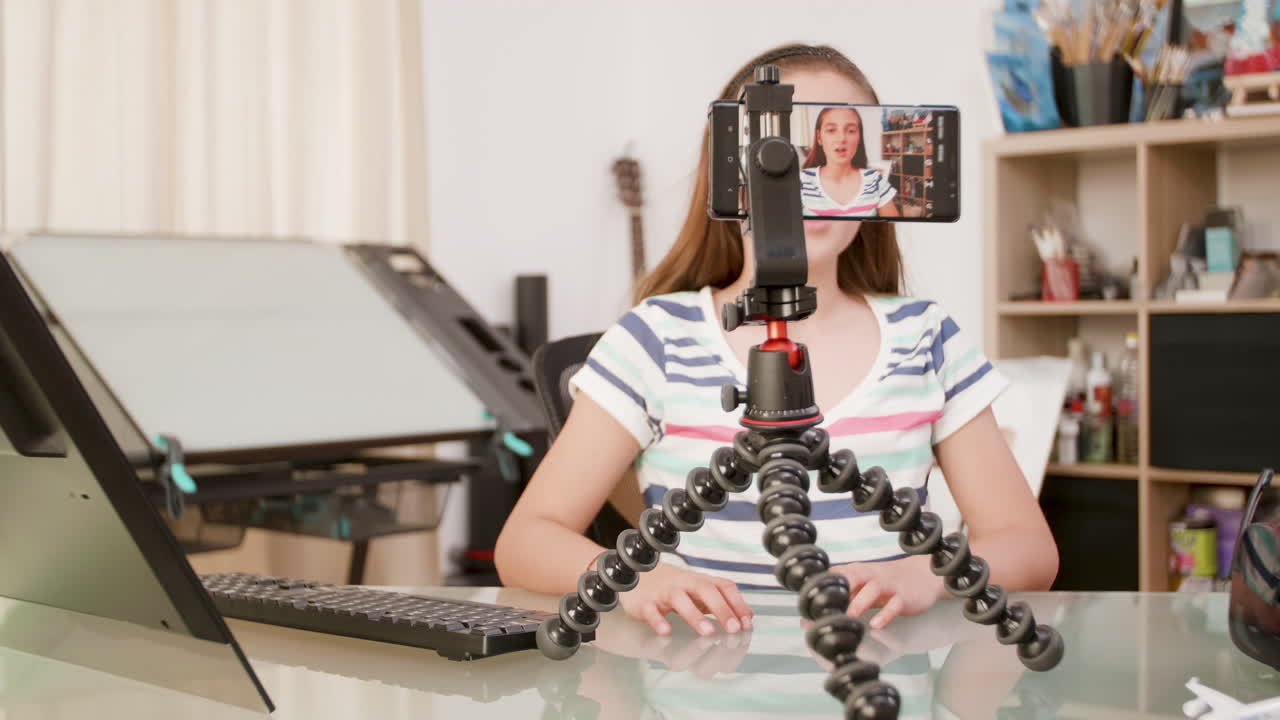 Teen girl vlogging with phone on tripod