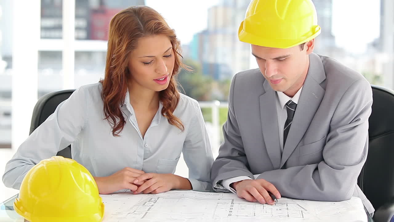 arquitectos sonrientes mirando los planos