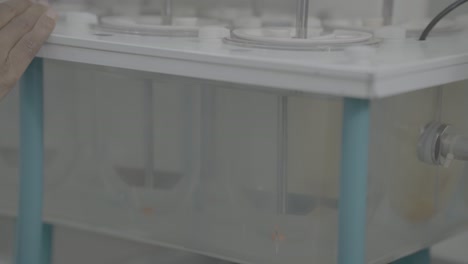 lab doctor adds tables to the quality check machine slog footage.
