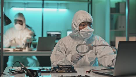 lab scientist examining chip with magnifying glass